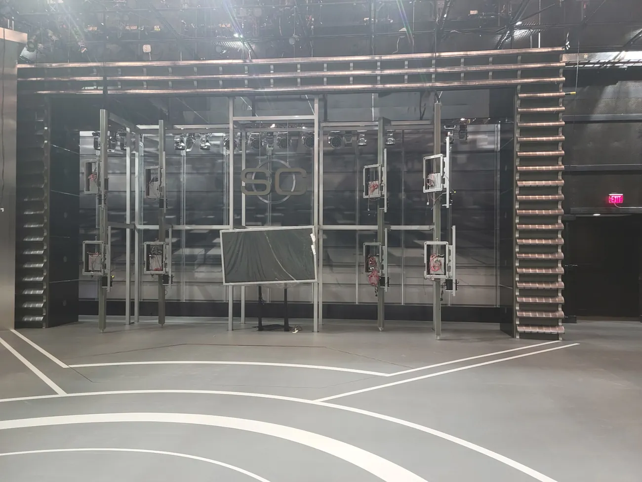 Gray studio floor with curved white lines in front of a set