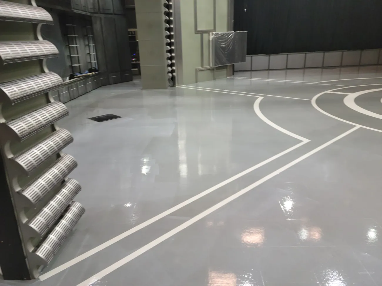 Glossy gray studio floor with white lines beside set panels