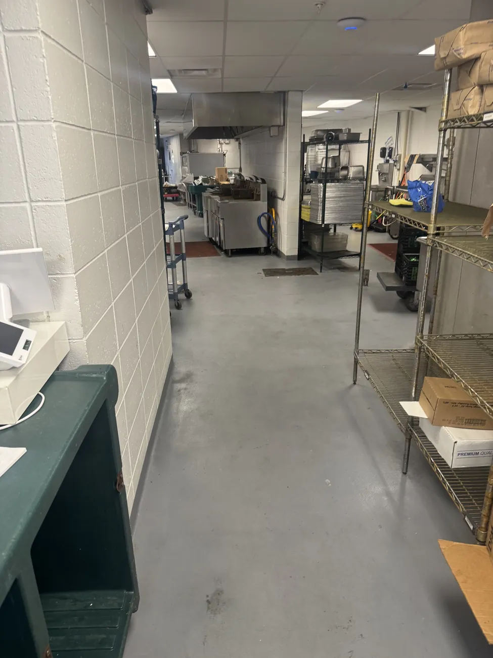 Gray seamless floor in a kitchen storage area with shelving